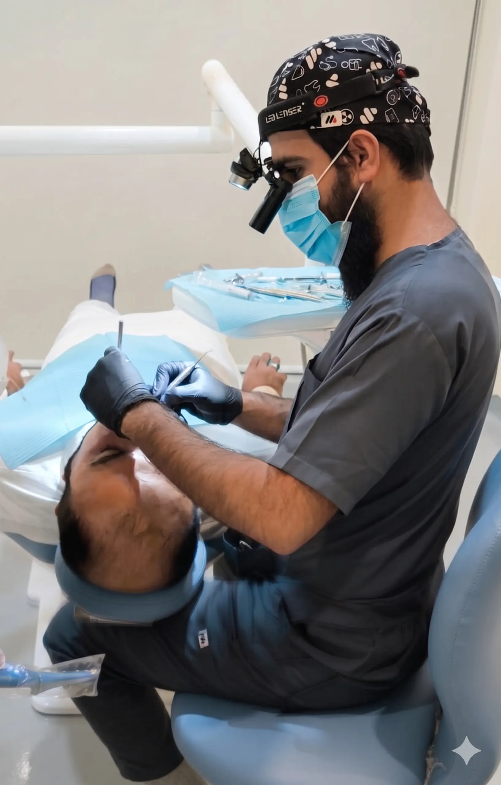 Dr. Saad Ahmed working under magnification at the chair, gloved hands steady over a patient